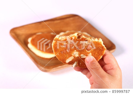 Toddler's hand holding a peanut rice cracker Toddler's hand holding a peanut rice cracker 85999787