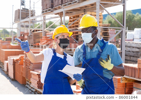 Two workers in masks keep track of the number of redbricks 86001844