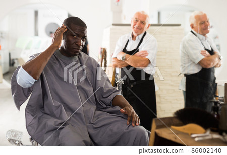 African man gazing at his haircut African man gazing at his haircut 86002140
