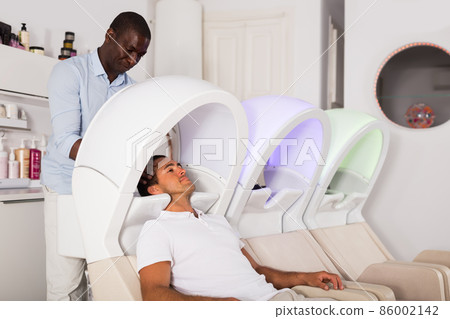 African American man washing hair to client 86002142