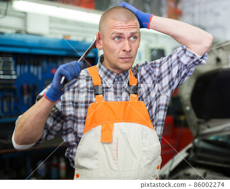 Professional auto mechanic posing in workshop 86002274