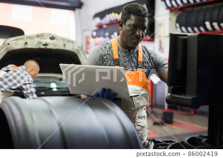 Automobile diagnosis. Car mechanic repairer looks for engine failure 86002419