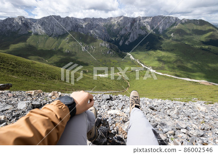 Hiker on high altitude mountain top enjoy the view 86002546