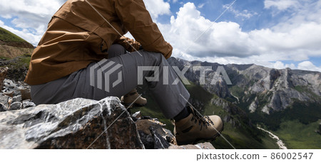 Hiker on high altitude mountain top enjoy the view 86002547