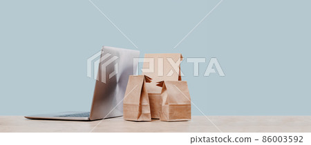 Laptop and paper shopping bags. Packages delivery online orders 86003592