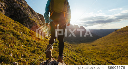 Solo woman backpacker hiking on alpine mountain peak Solo woman backpacker hiking on alpine mountain peak 86003676