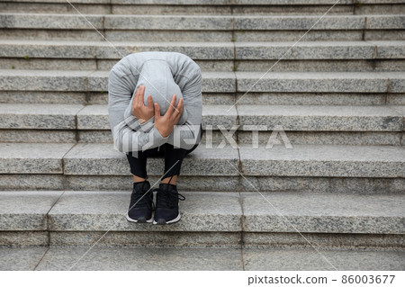 Upset woman sitting alone in city stairs 86003677