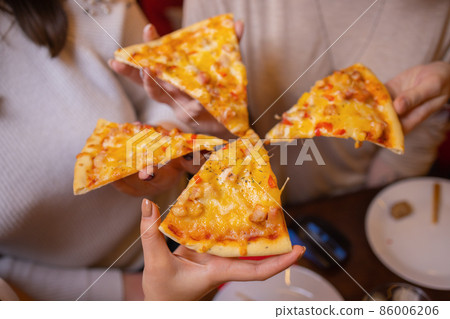 Image of teenage friends hands taking slices of pizza. 86006206