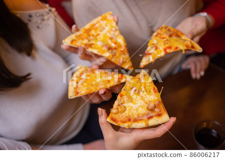 Image of teenage friends hands taking slices of pizza. 86006217