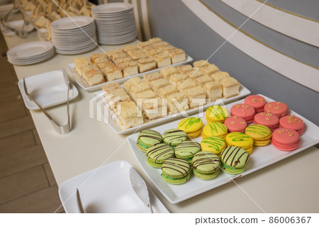 Candy bar on wedding party with a lot of different candies, cupcakes, souffle and cakes. 86006367