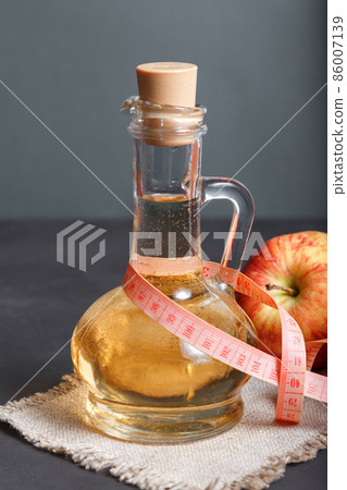 Slimming apple cider vinegar, homemade fermented diet product, fruit salad dressing. Healthy food Slimming apple cider vinegar, homemade fermented diet product, fruit salad dressing. Healthy food 86007139