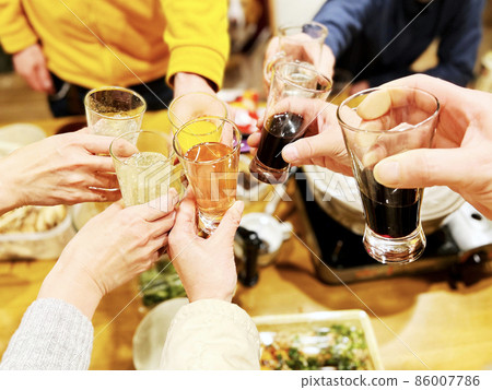 Men and women toasting at a hot pot party Men and women toasting at a hot pot party 86007786