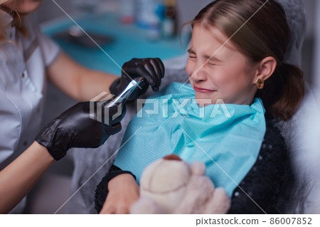 Dentist use anesthetic injection for tooth extraction in child. 86007852