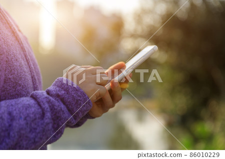 Woman using cellphone in city 86010229