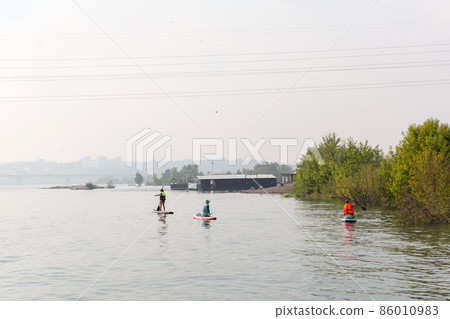 Irkutsk, Russia July 28, 2021 - People on small boats float on the river in the city. Editorial 86010983