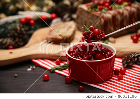 Cranberry sauce with Traditional French terrine on dark wooden background with Christmas decorations 86011190