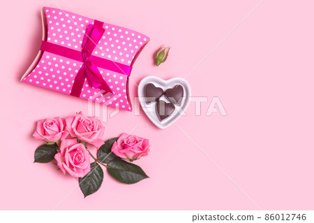 Pink beautiful roses, chocolate and gift box on pink background. Mothers day, Valentines Day 86012746