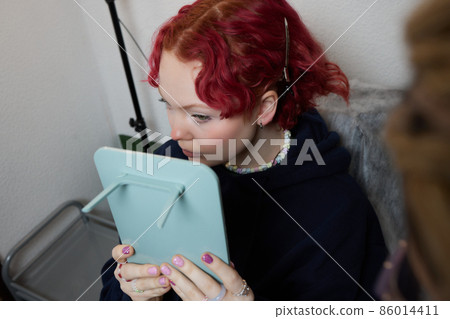 A beautician makes a puncture of the earlobe with a disposable device in a beauty salon. Ear piercing lobe. A beautician makes a puncture of the earlobe with a disposable device in a beauty salon. Ear piercing lobe. 86014411
