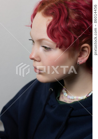 A beautician makes a puncture of the earlobe with a disposable device in a beauty salon. Ear piercing lobe. 86014456