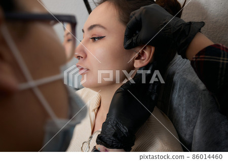 piercings on an ear. Conch and helix piercings close up. 86014460