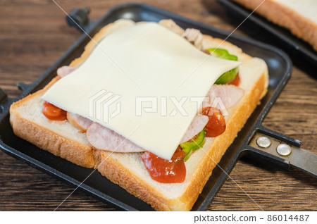 Put cheese on the ingredients of the hot sandwich 86014487