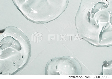 Transparent hyaluronic acid gel drops on a gray background. 86014512
