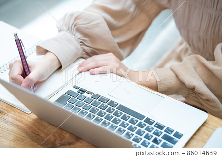 一位女士在使用筆記本電腦時做筆記 [零件切割] 86014639