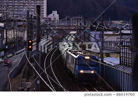 鐵路風景,冬天的黃昏,貨運火車經過深沉低音的風景,暮色場景,閃亮的車頭燈 鐵路風景,冬天的黃昏,貨運火車經過深沉低音的風景,暮色場景,閃亮的車頭燈 86014760