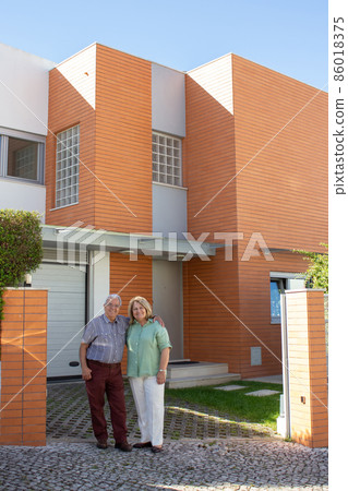 Fond retired family standing at entrance of new house Fond retired family standing at entrance of new house 86018375