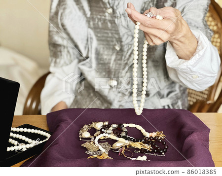 一位老婦人的手上有很多珠寶和一條珍珠項鍊 86018385
