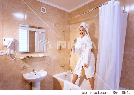 Woman is singing in the bathroom. 86018642