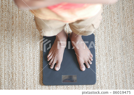 man's feet on weight scale close up. man's feet on weight scale close up. 86019475
