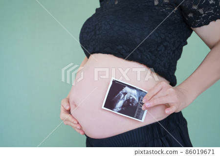 Pregnant woman's stomach and echo photo Pregnant woman's stomach and echo photo 86019671