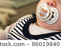 Baby girl with dummy in her mouth 86019840