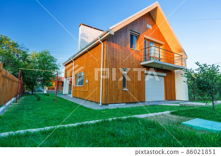 Wooden house with meadow in front of it Wooden house with meadow in front of it 86021851