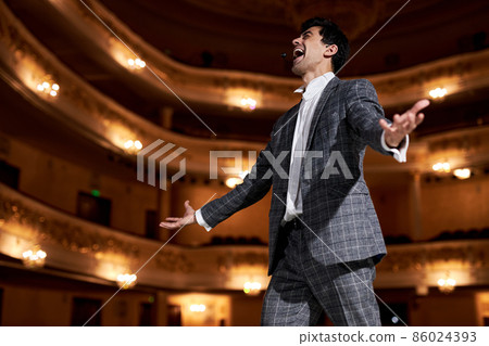 professional opera singer in elegant classic outfit, singing hit with open mouth 86024393
