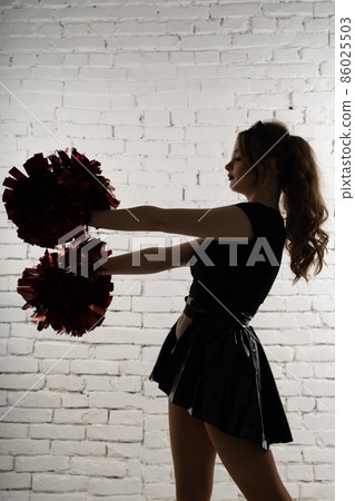 Young lady cheerleader posing in the studio, isolated on red and blue 86025503