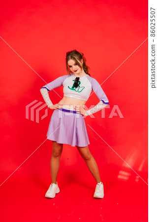 Young lady cheerleader posing in the studio, isolated on red and blue 86025507