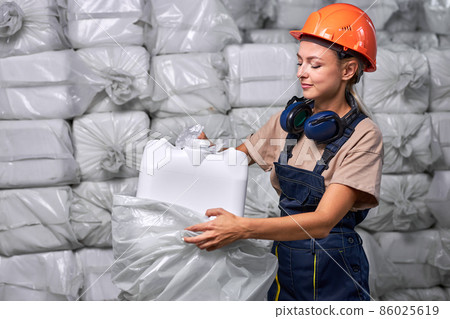 female engineer packing Plastic barrels with pesticides in factory, preparing for sale 86025619