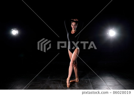 Beautiful Ballet Dancer Posing On Pointes. Ballerina Wearing Black Suit Is Going To Dance 86028019