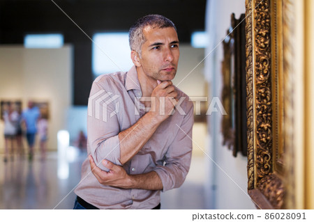 Adult male is visiting at the pictures exposition Adult male is visiting at the pictures exposition 86028091