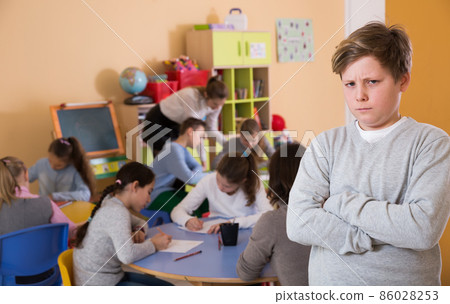 Boy standing, elementary age children drawing at class 86028253