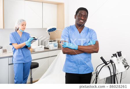 Confident cosmetologist in aesthetic medicine office with female assistant 86028261