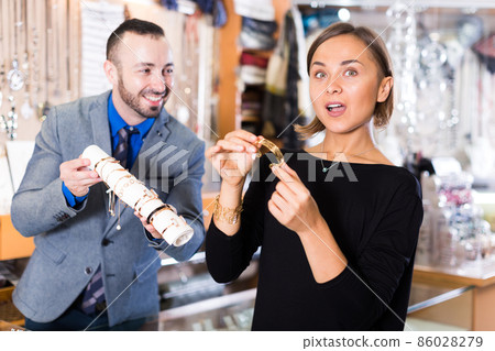 Positive female consumer trying bracelet Positive female consumer trying bracelet 86028279