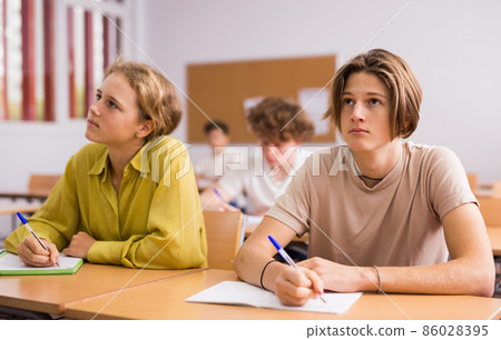 Teenagers doing tasks during lesson in school 86028395
