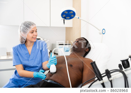 Afro american man having cavitation procedure in beauty clinic Afro american man having cavitation procedure in beauty clinic 86028968