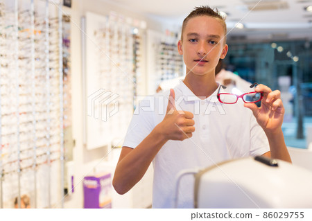 Satisfied teen boy trying on spectacles 86029755