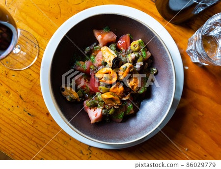 Mediterranean cuisine - mussels and tomatoes with arugula pesto closeup Mediterranean cuisine - mussels and tomatoes with arugula pesto closeup 86029779