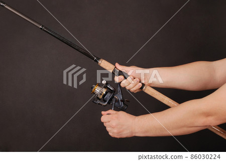 Hand holding a fishing rod 86030224