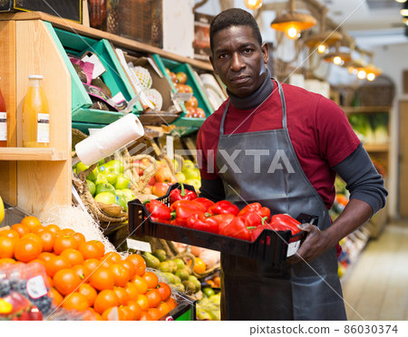 Salesman holding box with red peppers 86030374